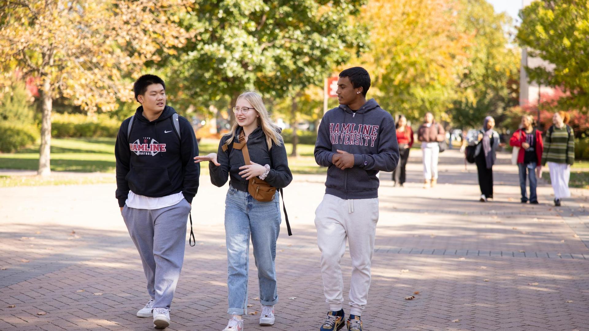 Students Aaron Yang, Tori Hutchinson, and Isaiah Watson walking on campus