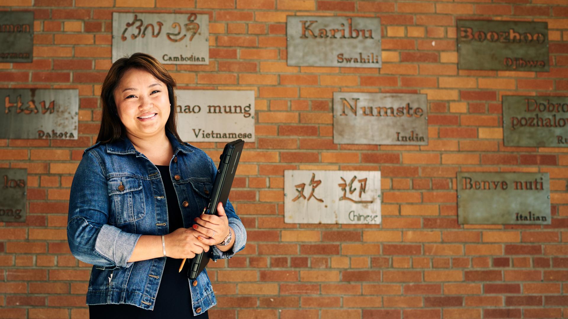 HSEL alumni Nouly with multi-language words on wall behind her