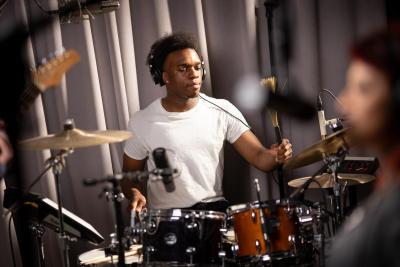 Student Joe Mason playing drums / percussion in Music Production program