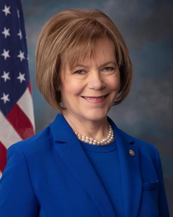 Headshot of Senator Tina Smith standing in front of flag
