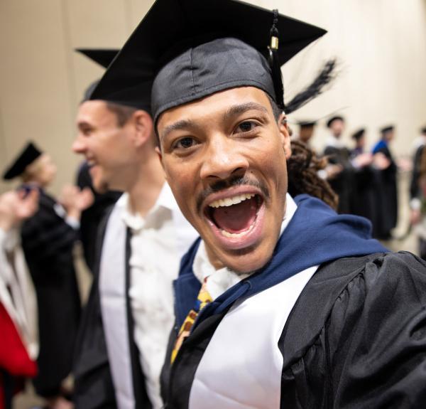 Graduating student in mortarboard, happily calling out