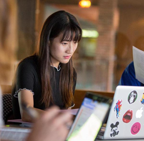 Woman in classroom looking seriously at her computer